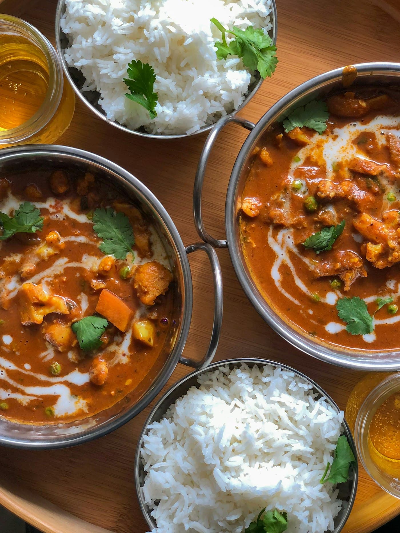 A feast of curries and steamed rice served in steel kadais